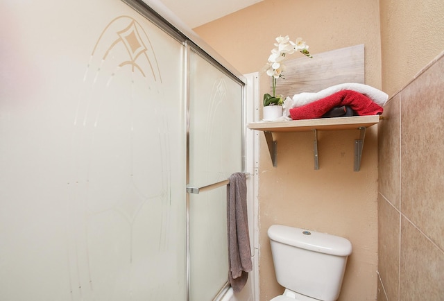 bathroom featuring toilet and an enclosed shower