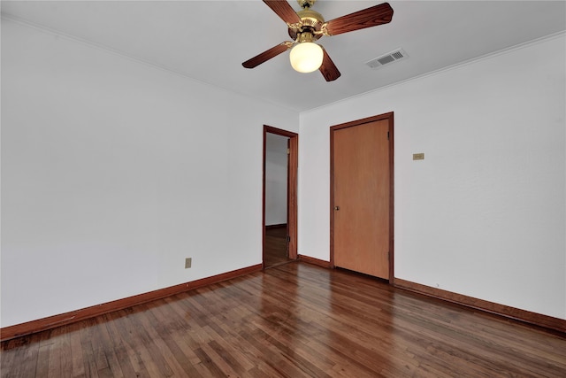 unfurnished room featuring dark wood-type flooring, ceiling fan, and ornamental molding