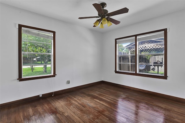 empty room with ornamental molding, ceiling fan, plenty of natural light, and dark wood-type flooring