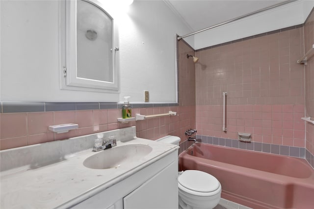 full bathroom with tiled shower / bath, backsplash, toilet, vanity, and tile walls