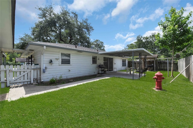 back of house with a patio and a lawn