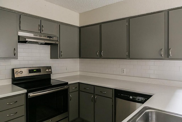 kitchen featuring decorative backsplash, appliances with stainless steel finishes, and a textured ceiling