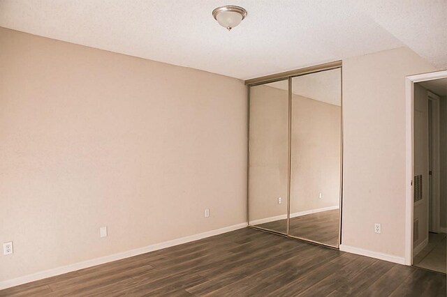 unfurnished bedroom with hardwood / wood-style flooring, a closet, and a textured ceiling