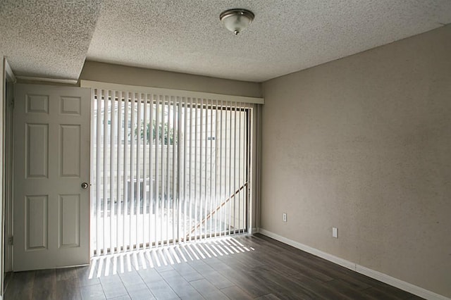 empty room featuring dark hardwood / wood-style flooring and a textured ceiling