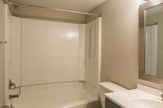 full bathroom featuring a textured ceiling, toilet, vanity, and tub / shower combination