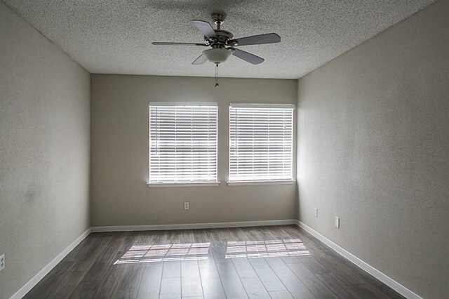 empty room with dark wood-type flooring, a textured ceiling, and ceiling fan