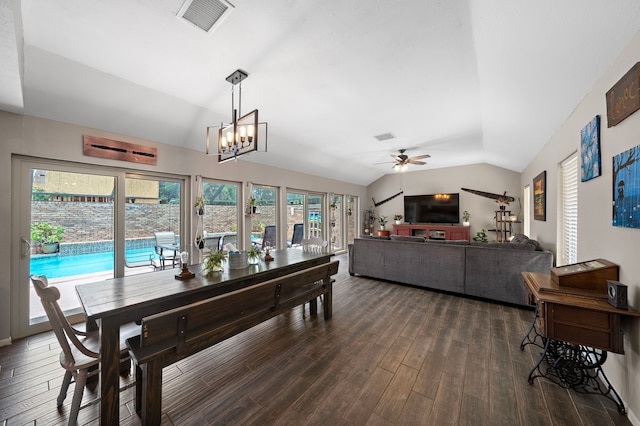 dining room with dark wood-type flooring, ceiling fan with notable chandelier, and lofted ceiling