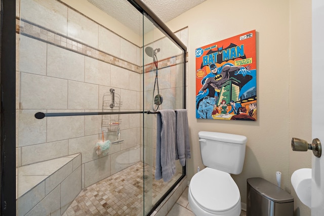 bathroom with an enclosed shower, a textured ceiling, and toilet