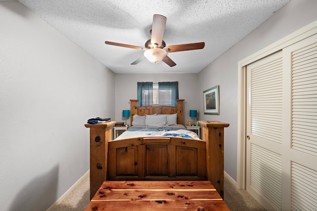 carpeted bedroom with a textured ceiling, ceiling fan, and a closet