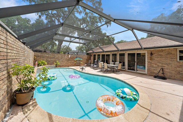 view of swimming pool featuring a patio area and a lanai