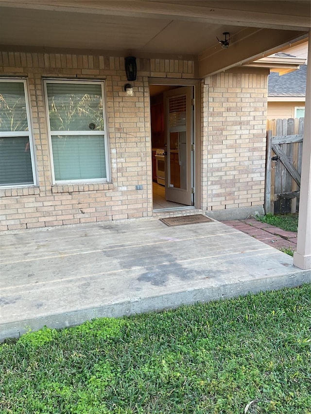 property entrance with brick siding and fence