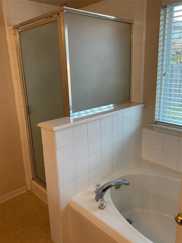 bathroom featuring a shower stall, a bath, and tile patterned floors