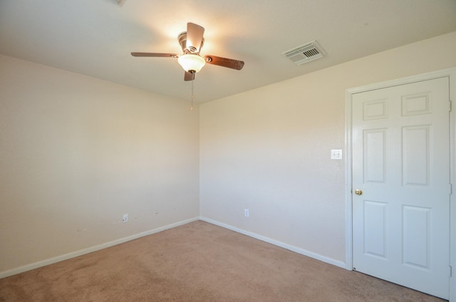 spare room with ceiling fan, carpet, visible vents, and baseboards