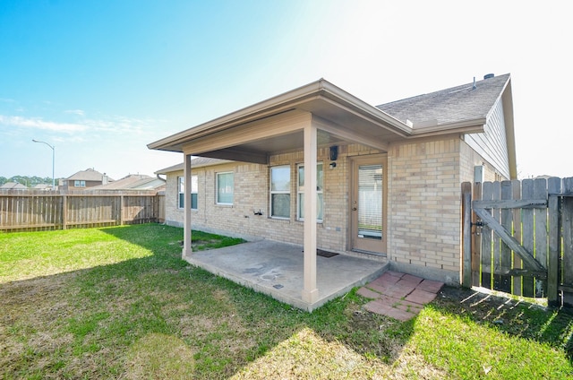 back of property featuring a patio area, brick siding, a lawn, and a fenced backyard