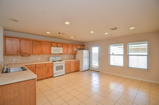 kitchen with white appliances, visible vents, decorative backsplash, light countertops, and a sink