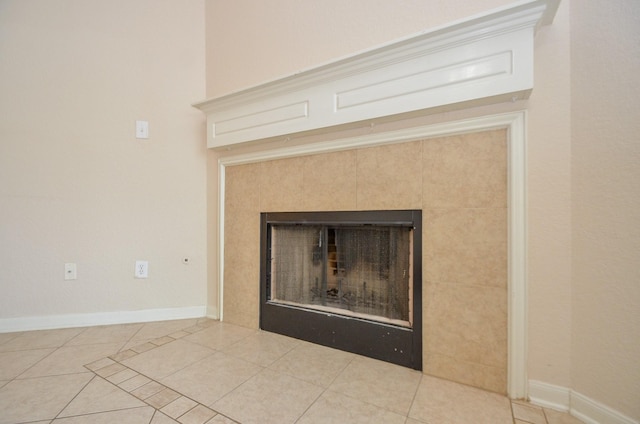 details featuring a tiled fireplace and baseboards