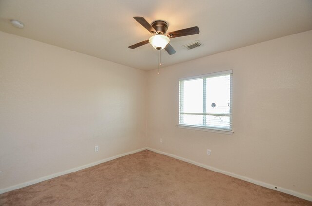 empty room featuring baseboards, visible vents, and light colored carpet