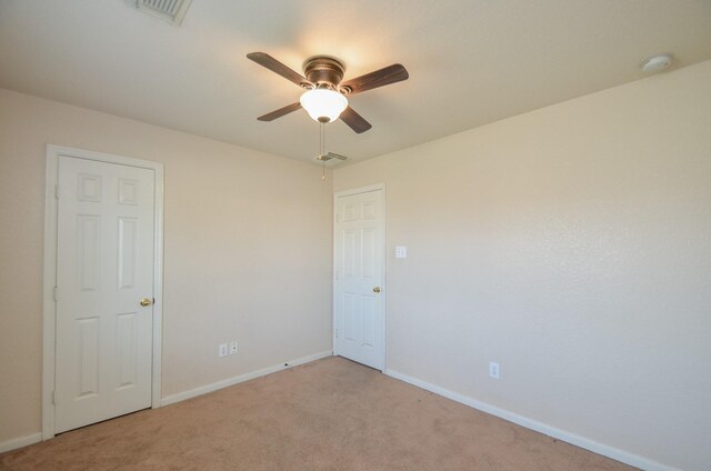 empty room with visible vents, light carpet, and baseboards