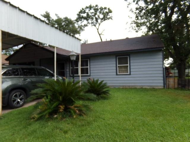 view of home's exterior with a yard and a carport