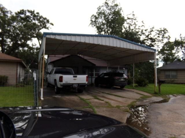 view of vehicle parking featuring a yard and a carport