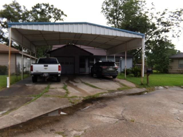 view of parking / parking lot with a lawn and a carport