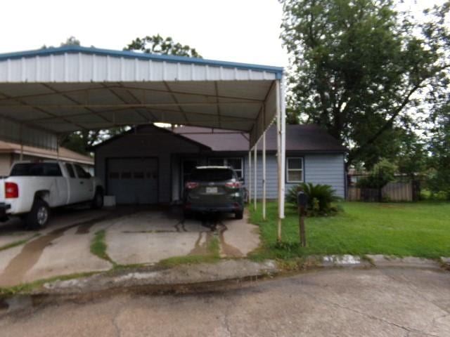 view of parking featuring a carport, a lawn, and a garage