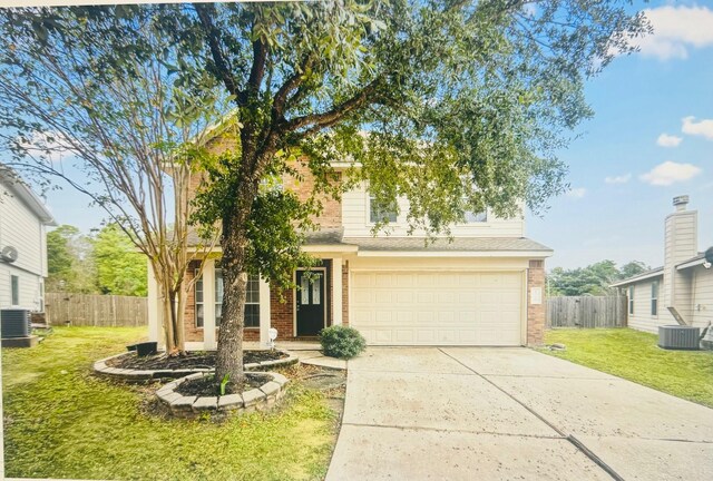 view of front of property with a garage, central AC, and a front lawn