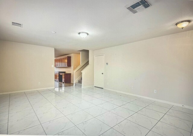 spare room featuring baseboards, stairs, and visible vents