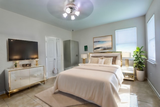 tiled bedroom featuring ceiling fan and multiple windows