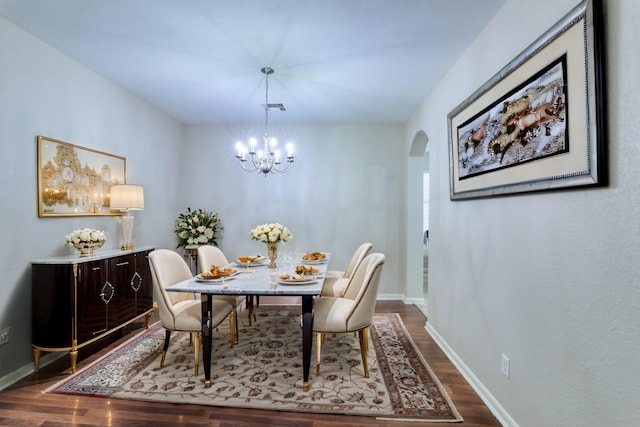 dining room with dark hardwood / wood-style floors and a chandelier