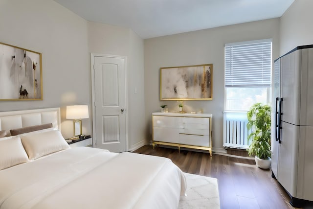 bedroom with radiator heating unit and dark wood-type flooring