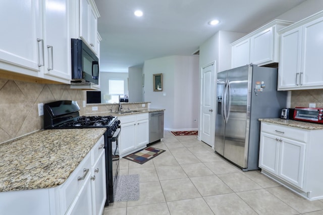 kitchen with black appliances, white cabinets, light stone counters, and tasteful backsplash