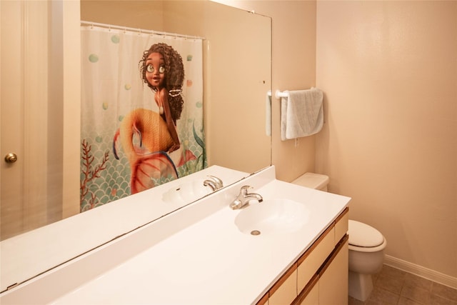 bathroom with tile patterned flooring, vanity, and toilet