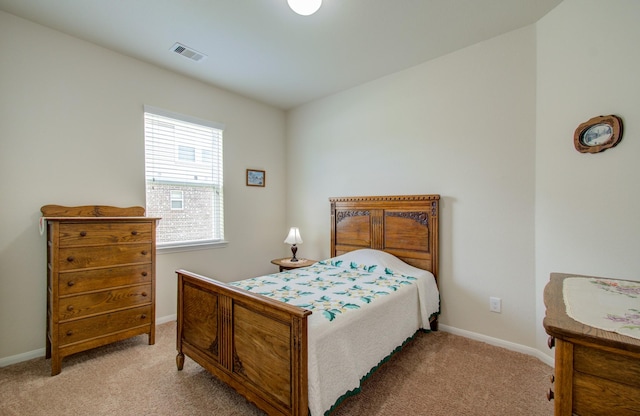 bedroom with baseboards, light colored carpet, and visible vents