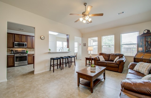 living area with baseboards, a ceiling fan, and visible vents