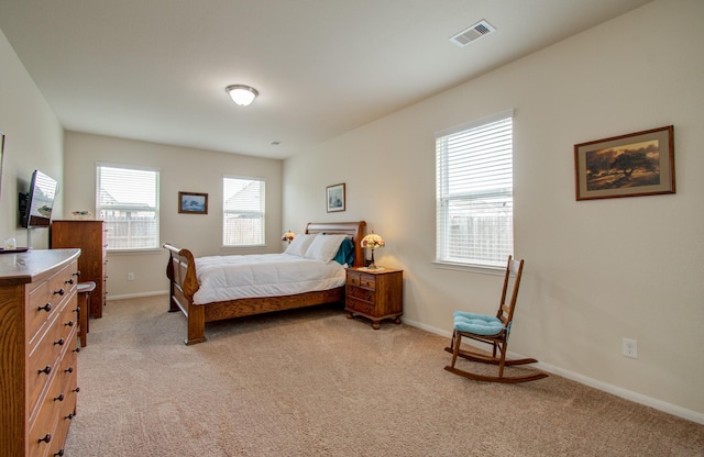 bedroom with baseboards, light carpet, and visible vents