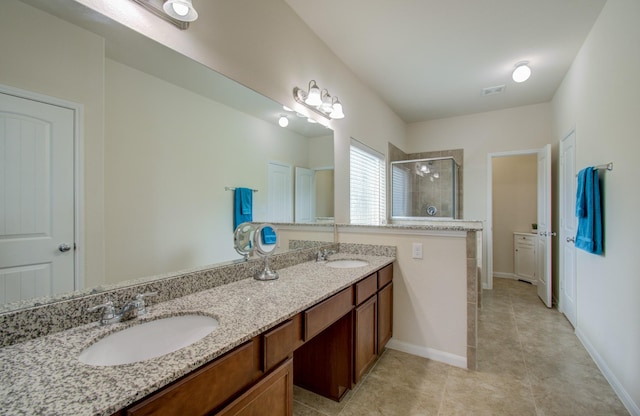full bathroom featuring visible vents, a sink, double vanity, and a shower stall
