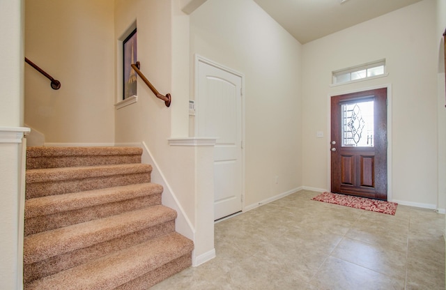 foyer with stairs and baseboards