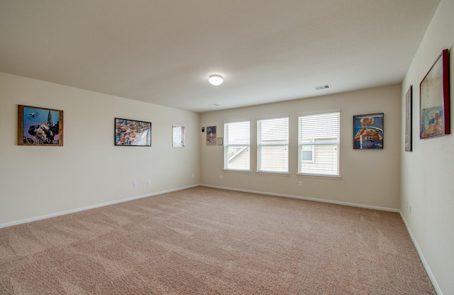 unfurnished room with light colored carpet, baseboards, and visible vents
