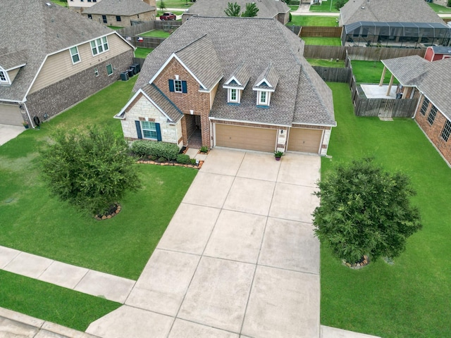 view of front of home with driveway, a front yard, a residential view, fence, and a shingled roof