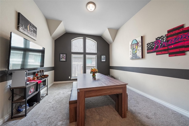 carpeted office space featuring vaulted ceiling