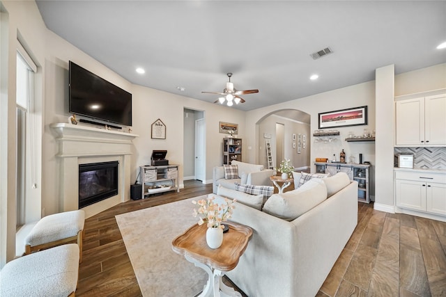 living room featuring bar area and ceiling fan