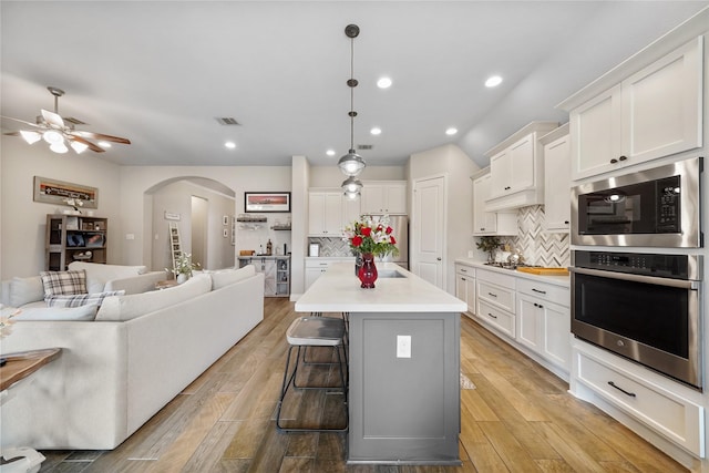 kitchen with white cabinetry, tasteful backsplash, pendant lighting, and appliances with stainless steel finishes