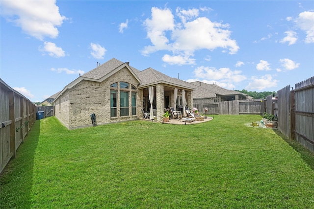 rear view of property featuring a patio and a yard