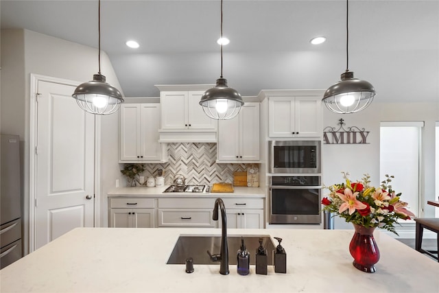 kitchen featuring decorative light fixtures, white cabinets, decorative backsplash, and appliances with stainless steel finishes