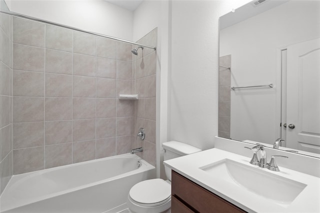 full bathroom featuring vanity, tiled shower / bath combo, and toilet