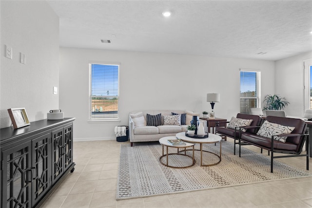 living room featuring a textured ceiling and light tile patterned flooring