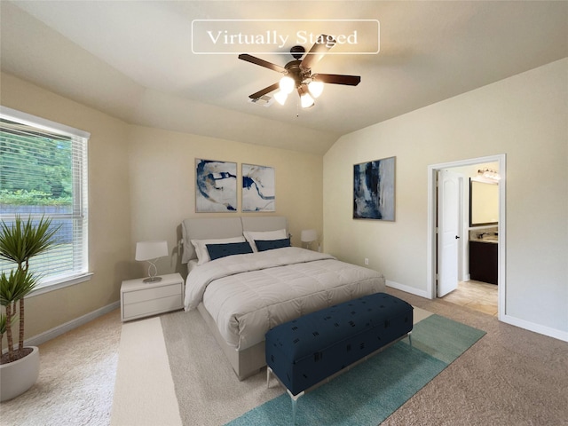 carpeted bedroom with ceiling fan, connected bathroom, and lofted ceiling