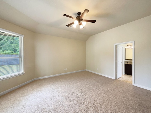 carpeted spare room featuring ceiling fan and lofted ceiling