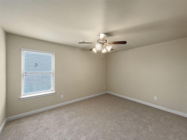 carpeted empty room with ceiling fan and a wealth of natural light